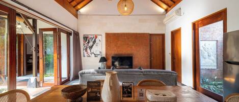 A spacious living room with a fireplace, wooden flooring, and a large sofa.
