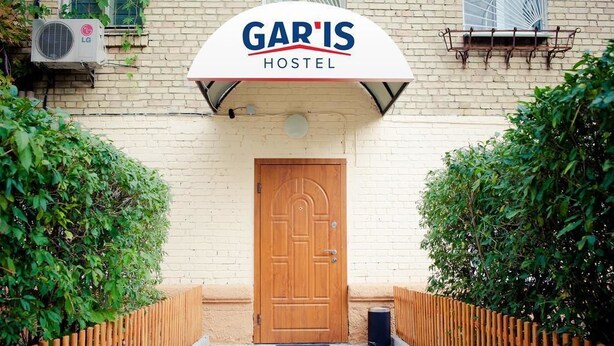 Une auberge de jeunesse appelée GARIS, avec une porte en bois et une enseigne au-dessus.