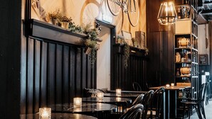 L’intérieur d’un restaurant avec des lambris en bois, des tables rondes et des chaises.