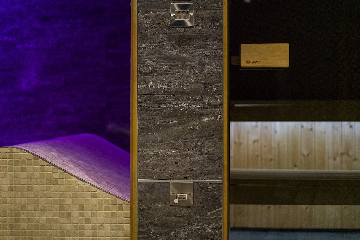 Un baño con piso de madera, una toalla morada y un letrero que dice "Ho Serv".