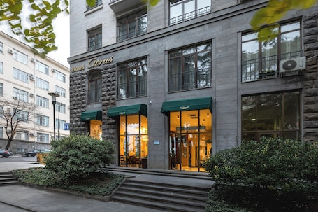 A hotel with a stone facade, large windows, and a green awning.. Hotel Citrus