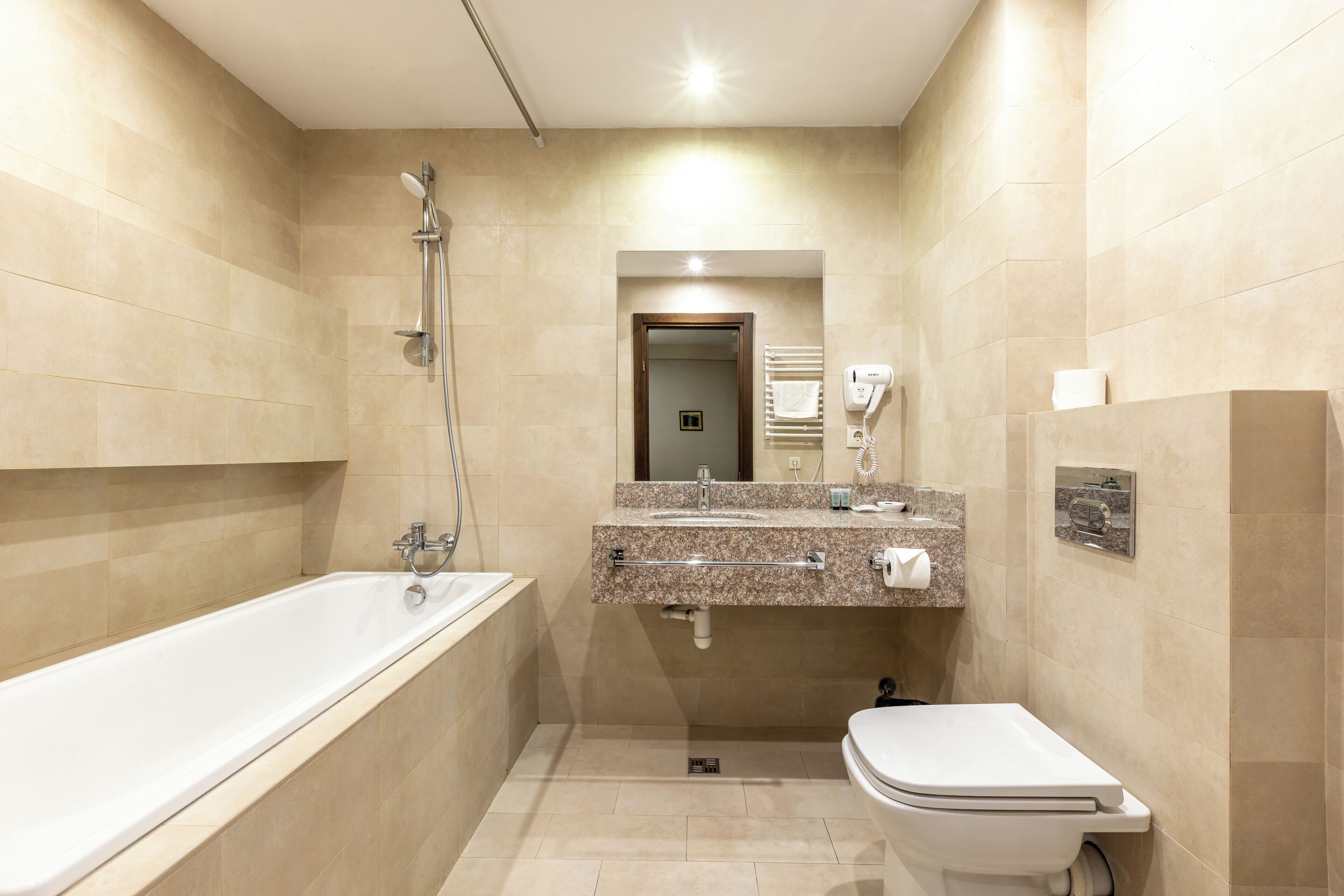 A modern bathroom with a bathtub, sink, and toilet.