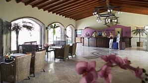 A reception area with a reception desk, chairs, and a large chandelier. - Club Anastasia Hotel (Marmaris)