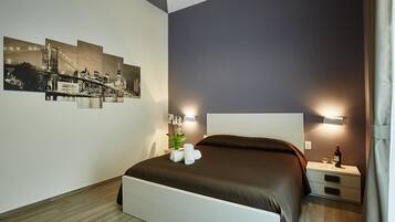 Camera d'albergo moderna con un grande letto, un comodino e una lampada a parete.