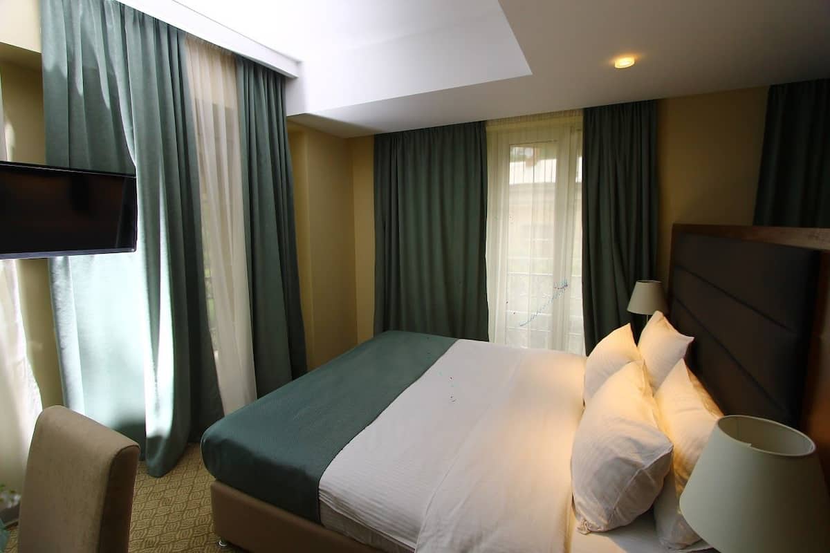 Une chambre d’hôtel équipée d’un lit, d’une télévision, d’un bureau et d’une chaise.