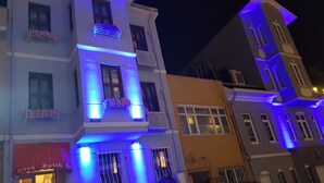 Un edificio de varios pisos con balcones y una tienda en la planta baja.