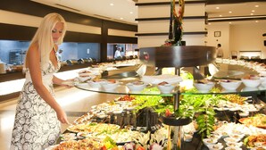 A buffet with various dishes and a woman serving food. - Side Prenses Resort Hotel & Spa - All Inclusive (Manavgat)