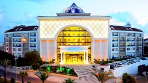 A hotel with a large central entrance, multiple balconies, and a distinctive dome-shaped roof. - Side Prenses Resort Hotel & Spa - All Inclusive (Manavgat)