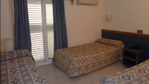 A hotel room with a bed, a small table, and a window with curtains. - Hotel Roma Reial (Barcelona)