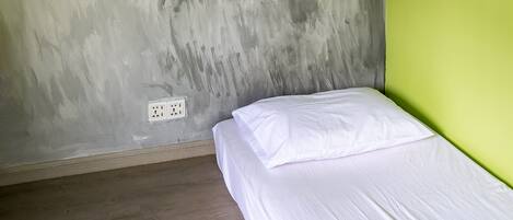 Een kamer met een bed, een muurschildering en een groene accentmuur.
