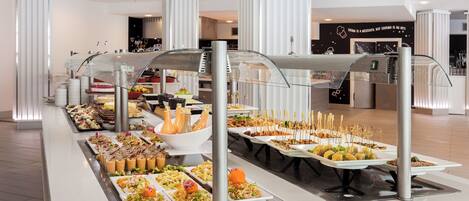 A buffet with various food items and a beverage station.