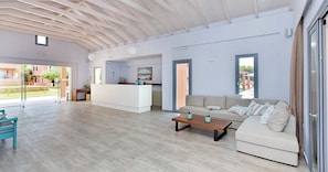 Un amplio salón con sofá, mesa de centro y vistas al exterior.