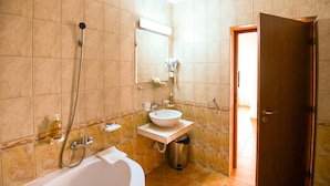 A bathroom with a bathtub, a sink, and a shower.