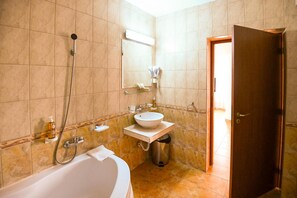 Un baño con bañera, lavamanos y ducha.