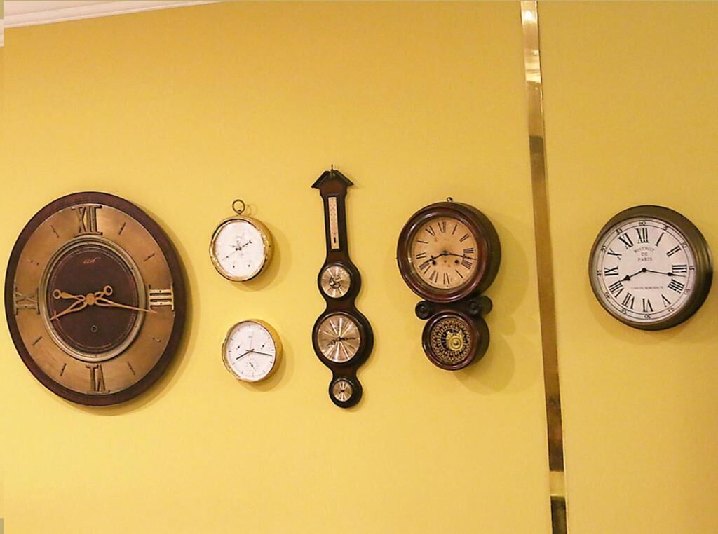 Een verzameling wandklokken in verschillende stijlen en maten.