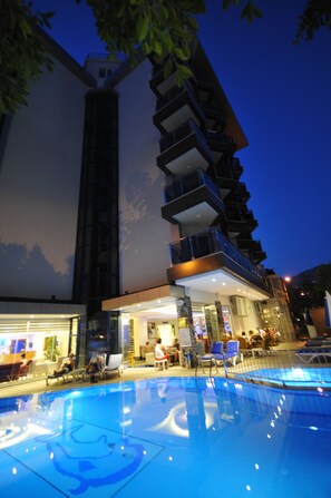 Una piscina al aire libre, sombrillas, tumbonas