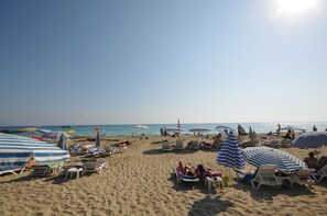 A beach with sun loungers and umbrellas, a clear sky, and the ocean in the background. - Kleopatra Micador Hotel (Alanya)