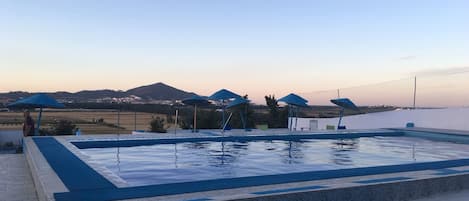 Piscina externa sazonal, funciona das 10h às 18h, guarda-sóis