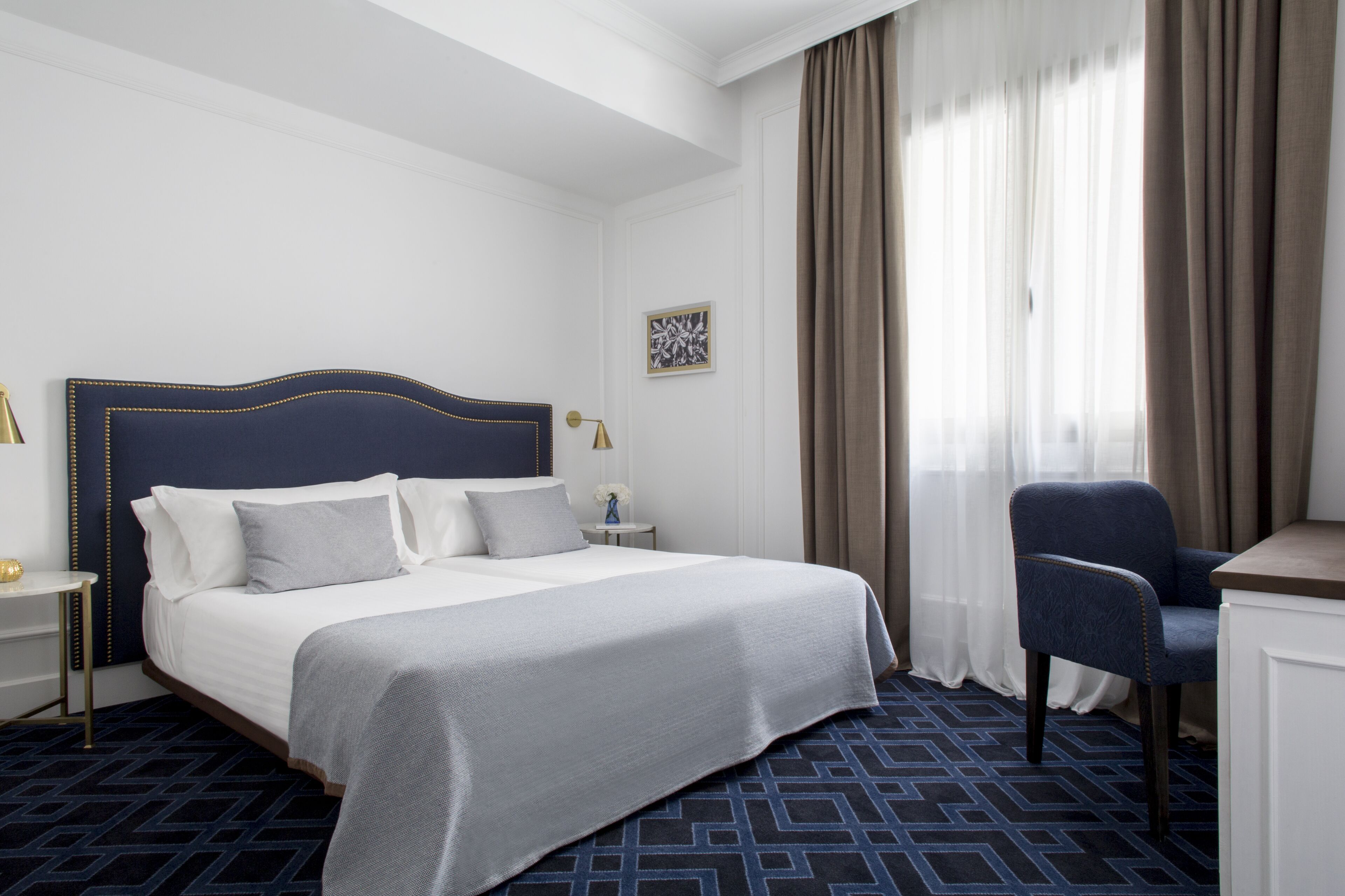 Een hotelkamer met een groot bed, een bureau en een stoel.