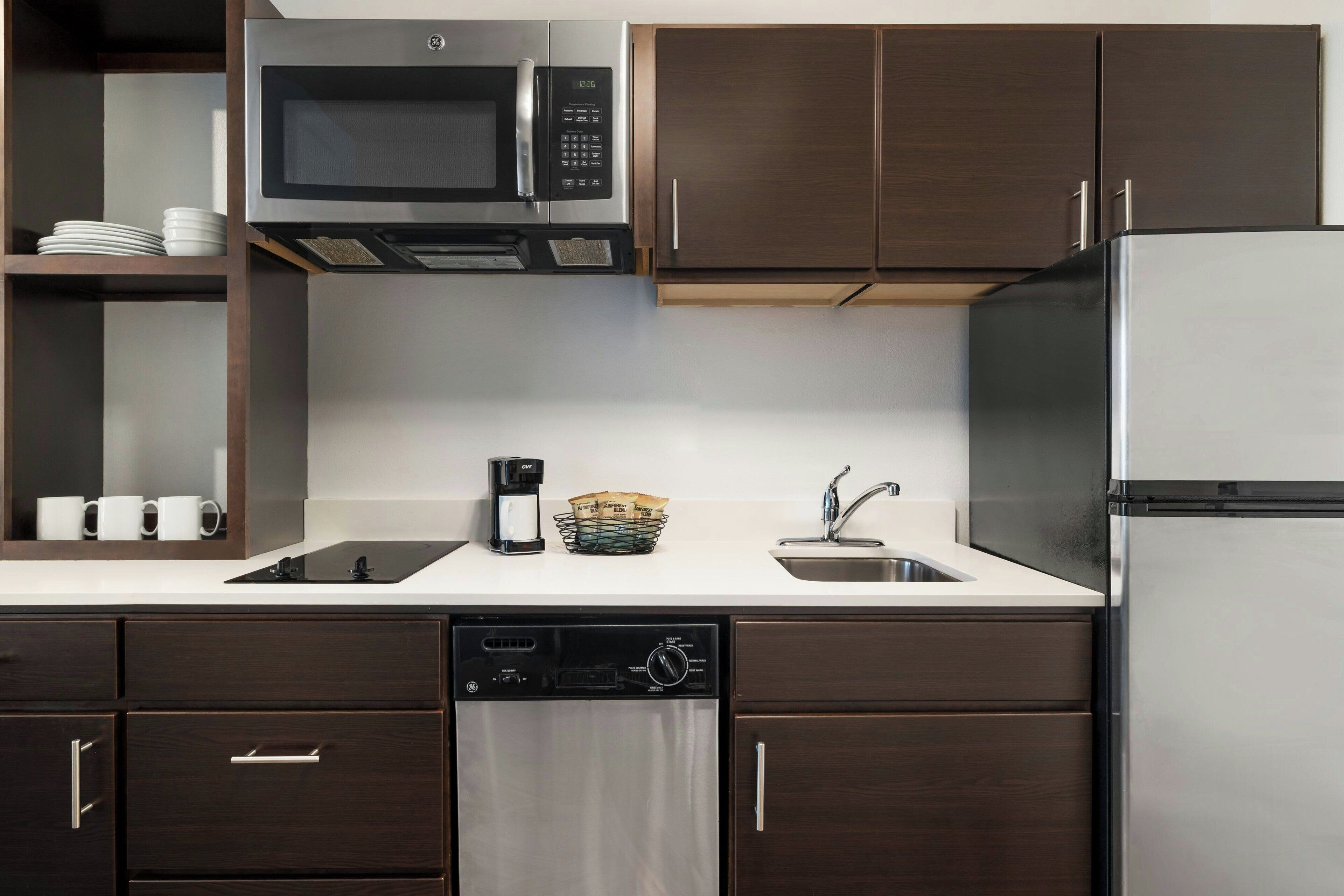 A modern kitchen with a built-in microwave, dishwasher, and refrigerator.