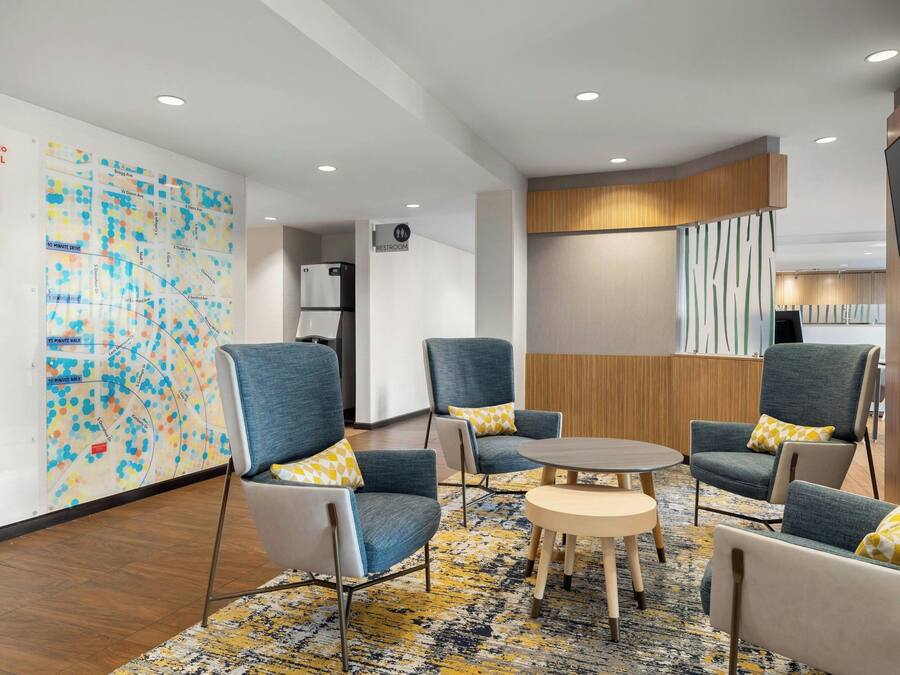 A modern lounge area with comfortable seating, a small round table, and a map on the wall.