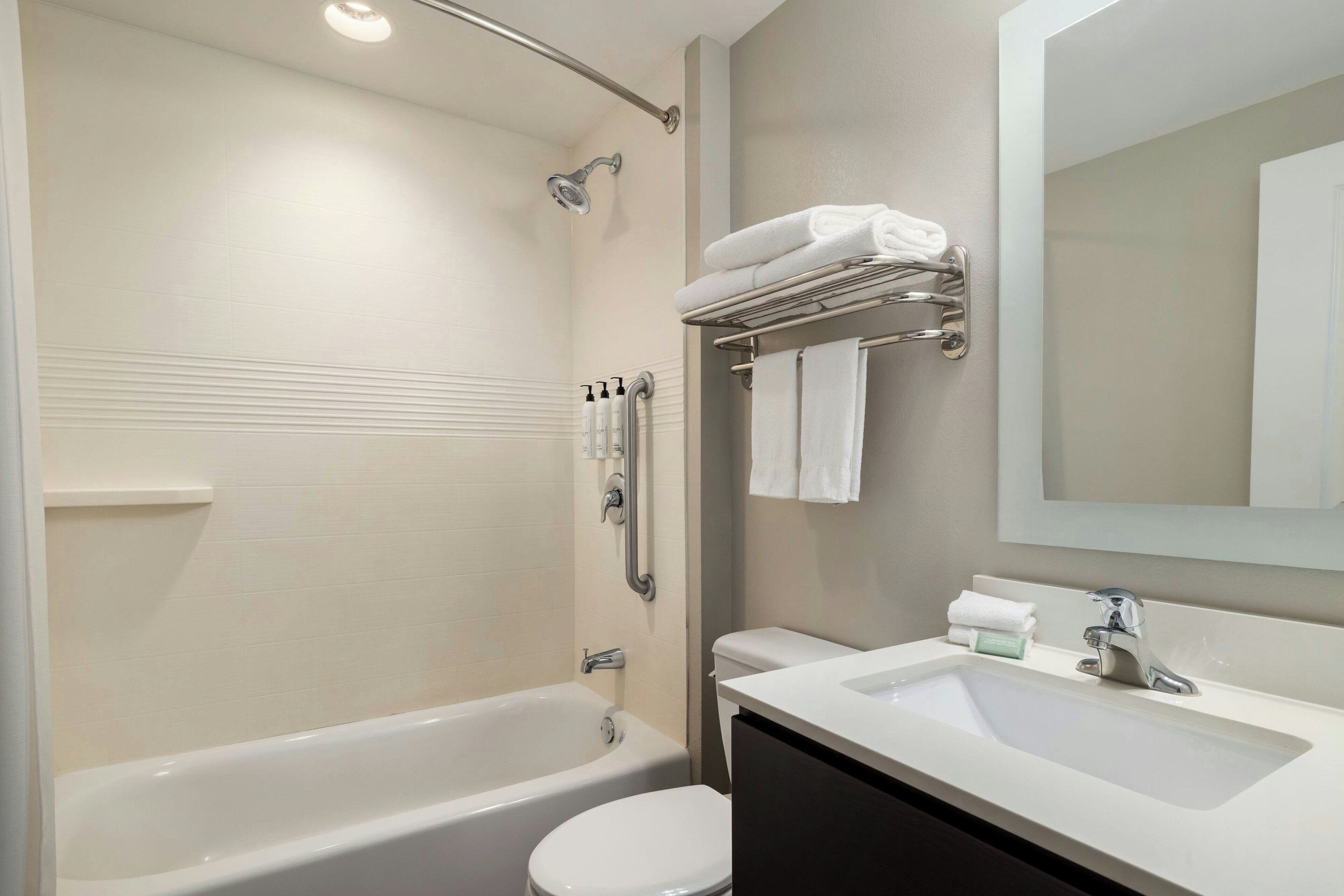 A modern bathroom with a bathtub, toilet, and sink.