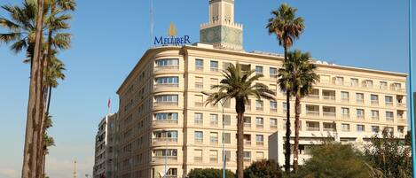 A large hotel with a prominent tower and multiple balconies.
