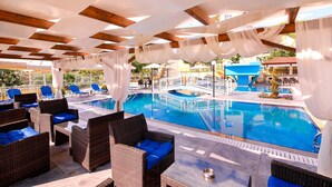 A poolside area with wicker furniture and a view of the pool. - Diamond Hotel (Thasos)