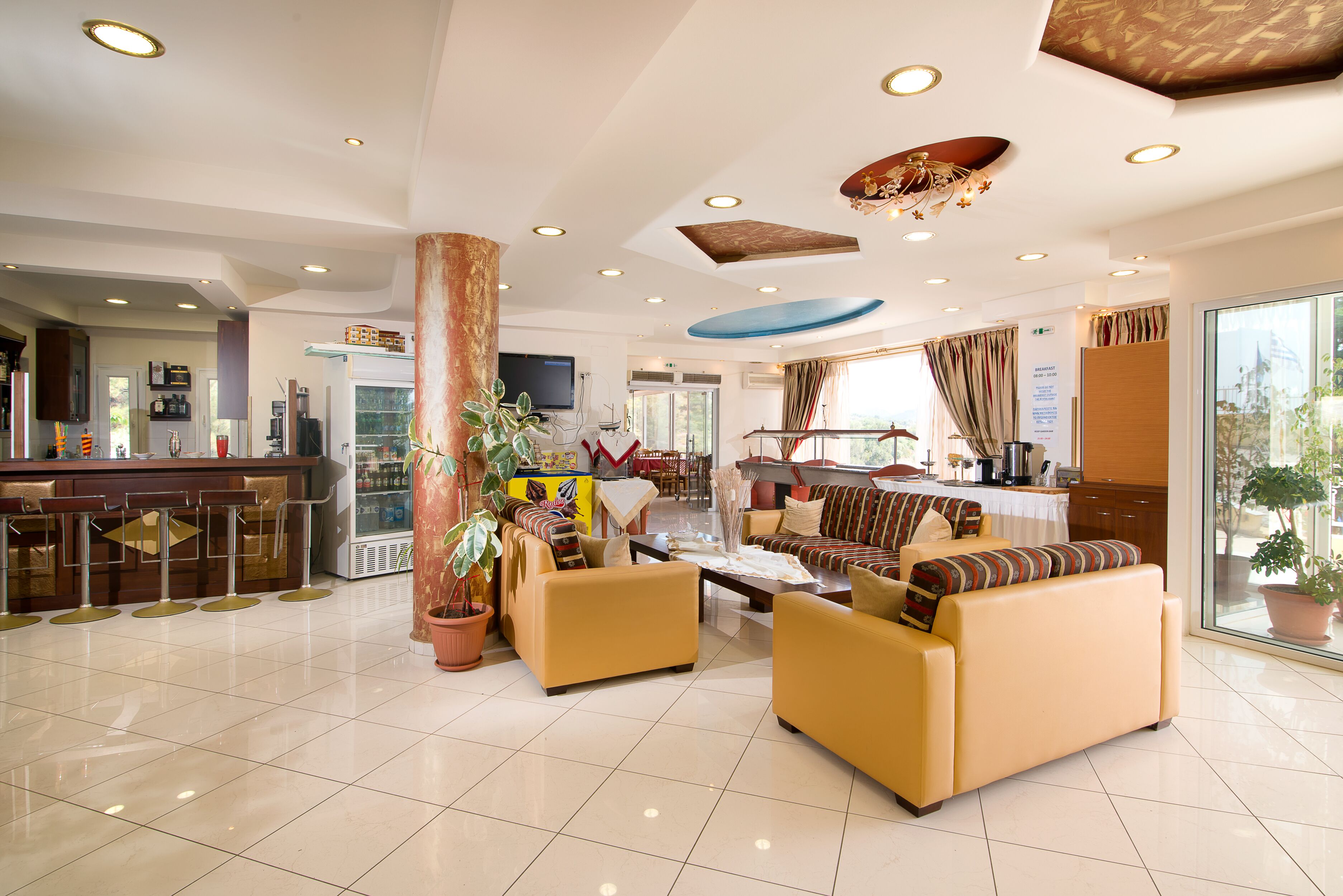A spacious lobby with a bar area, seating arrangements, and a large window offering a view.