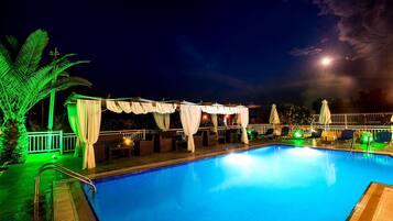 Relax by the pool surrounded by lounge chairs and umbrellas.