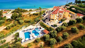 An aerial view of a coastal hotel with a swimming pool, beach access, and ocean views. - Diamond Hotel (Thasos)