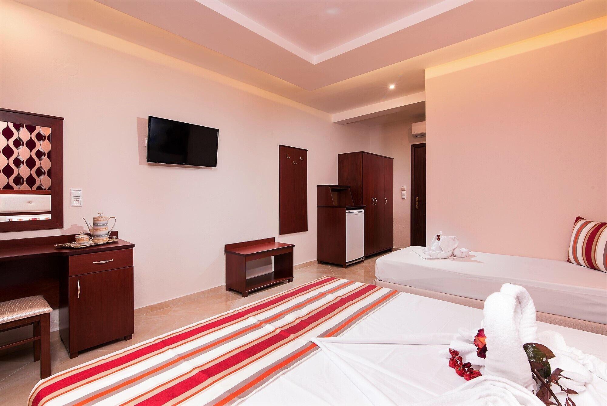 A hotel room with a bed, a desk, a TV, a wardrobe, and a bathroom.