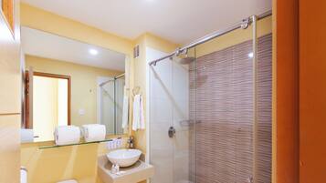 Une salle de bain moderne avec une douche à parois de verre, un lavabo blanc et un miroir au-dessus du lavabo.
