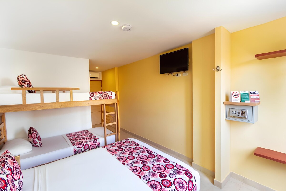 A room with bunk beds, a TV mounted on the wall, and a security keypad.