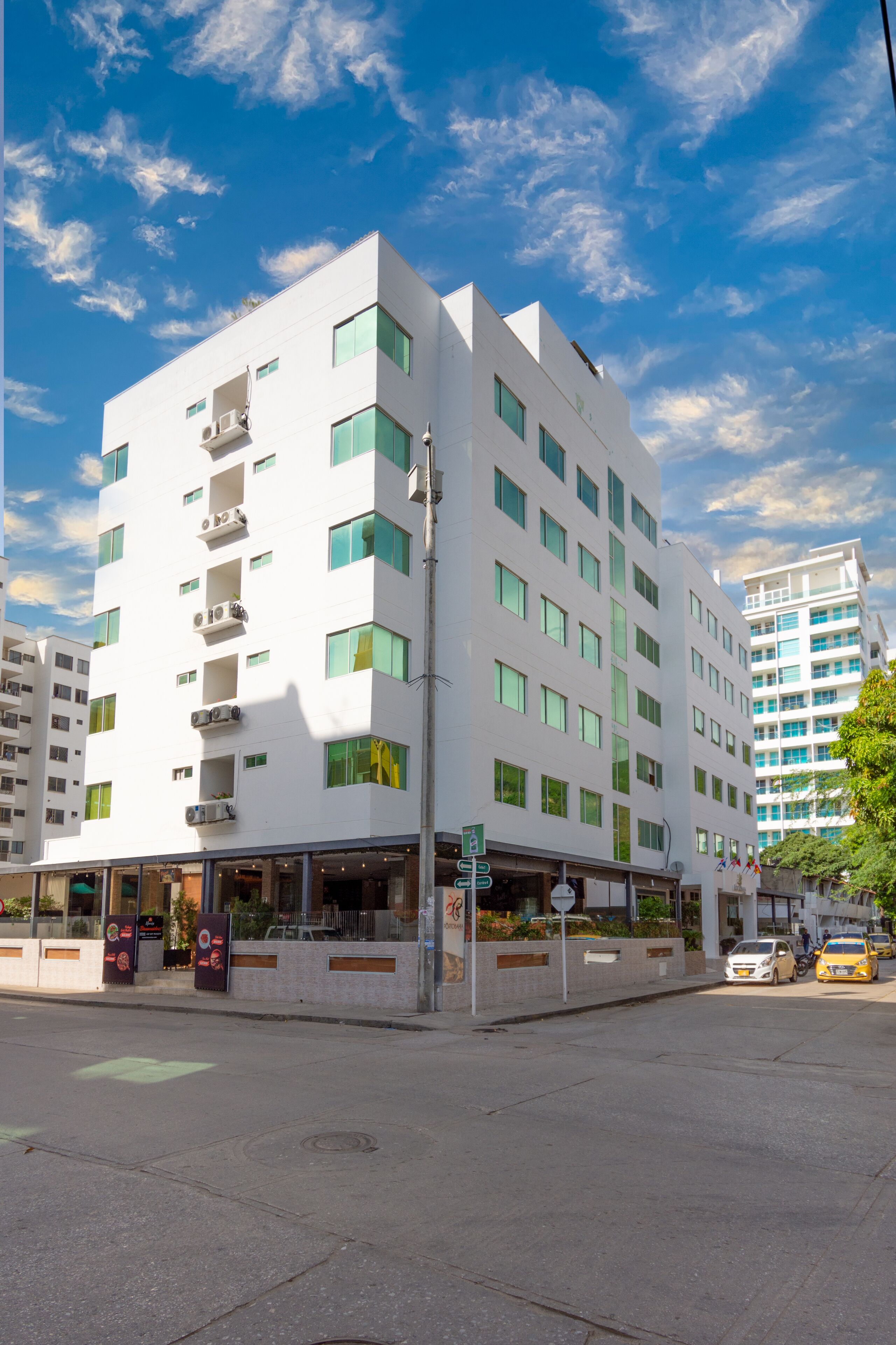 A modern multi-story hotel with a flat facade, large windows, and a ground-level restaurant.