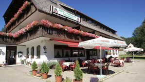 A traditional European hotel with outdoor seating, flower boxes, and a sign indicating it is a restaurant. - Hotel-Restaurant SchöpPerle (Häusern)