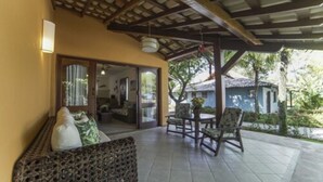 An outdoor patio area with a sofa, chairs, and a table. - Mar Paraíso Hotel (Porto Seguro)