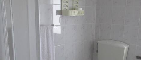 A small, clean bathroom with a toilet, sink, and a towel rack.