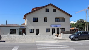 A two-story building with a sign indicating it is a guesthouse. - Alojamento Baleal à Vista (Peniche)