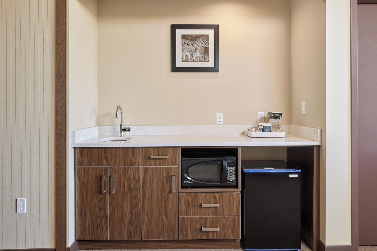 A compact kitchenette with a microwave, a coffee maker, and a small refrigerator.