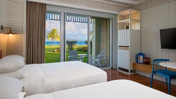 Habitación de hotel con cama, televisión, escritorio y vista al océano.