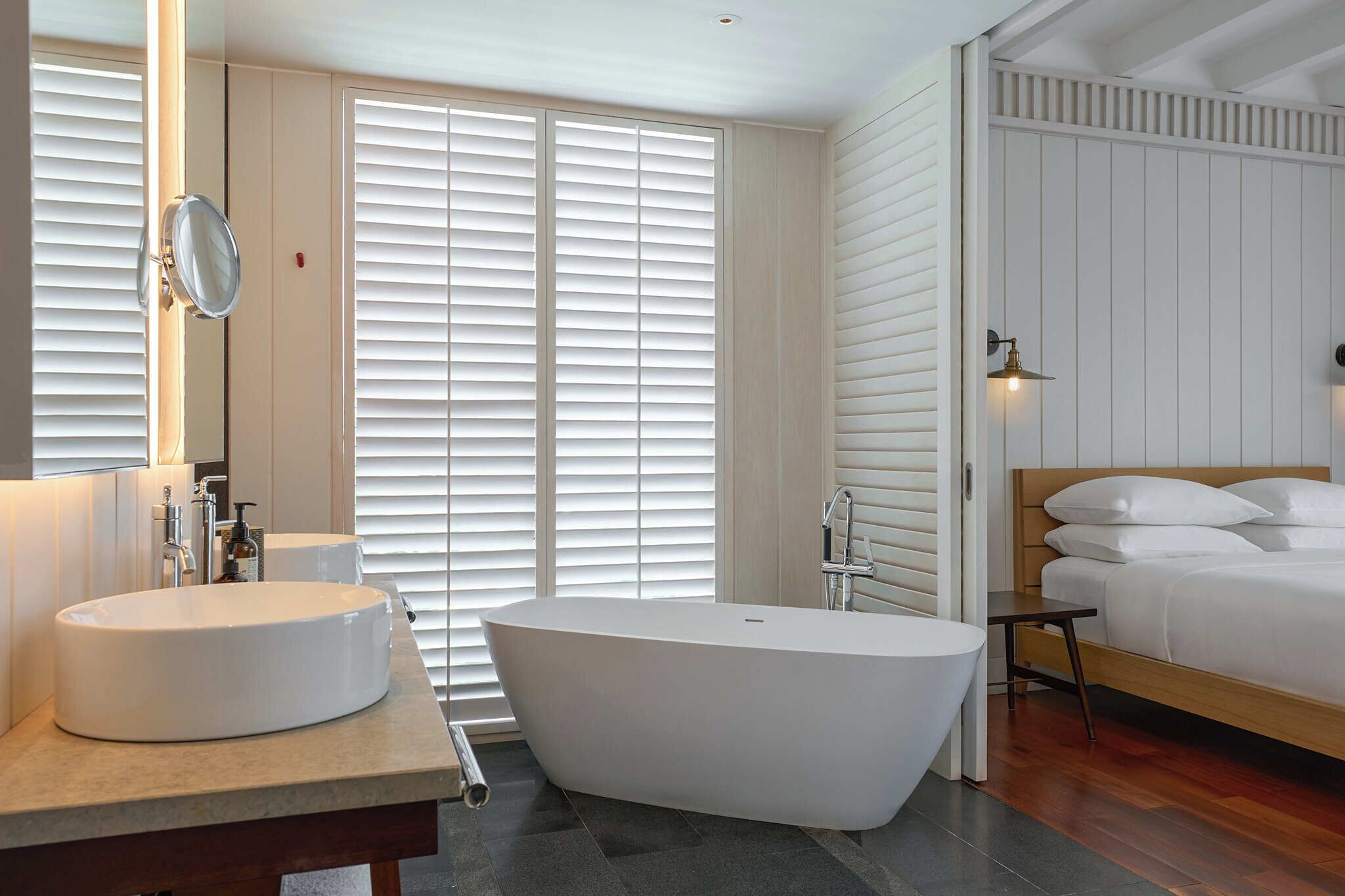 Une salle de bain moderne avec une baignoire sur pieds, un meuble-lavabo à deux vasques et un grand miroir.