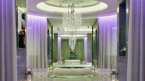 A luxurious hallway with a central circular seating area, a large chandelier, and mirrored walls. - Intercontinental Doha Residences by IHG (Doha)