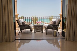 A balcony with wicker furniture, a small table, and a vase with flowers. - Intercontinental Doha Residences by IHG (Doha)