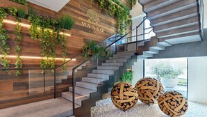 A modern staircase with a wooden wall and greenery, leading to a room with a white floor and decorative wooden spheres. - Intercontinental Doha Residences by IHG (Doha)