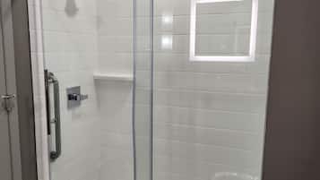 Une salle de bain moderne avec une douche à parois de verre, des toilettes et un lavabo.