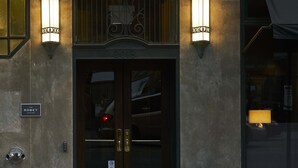 A building facade with a dark entrance, two wall-mounted lights, and a sign reading "The Robey Chicago".