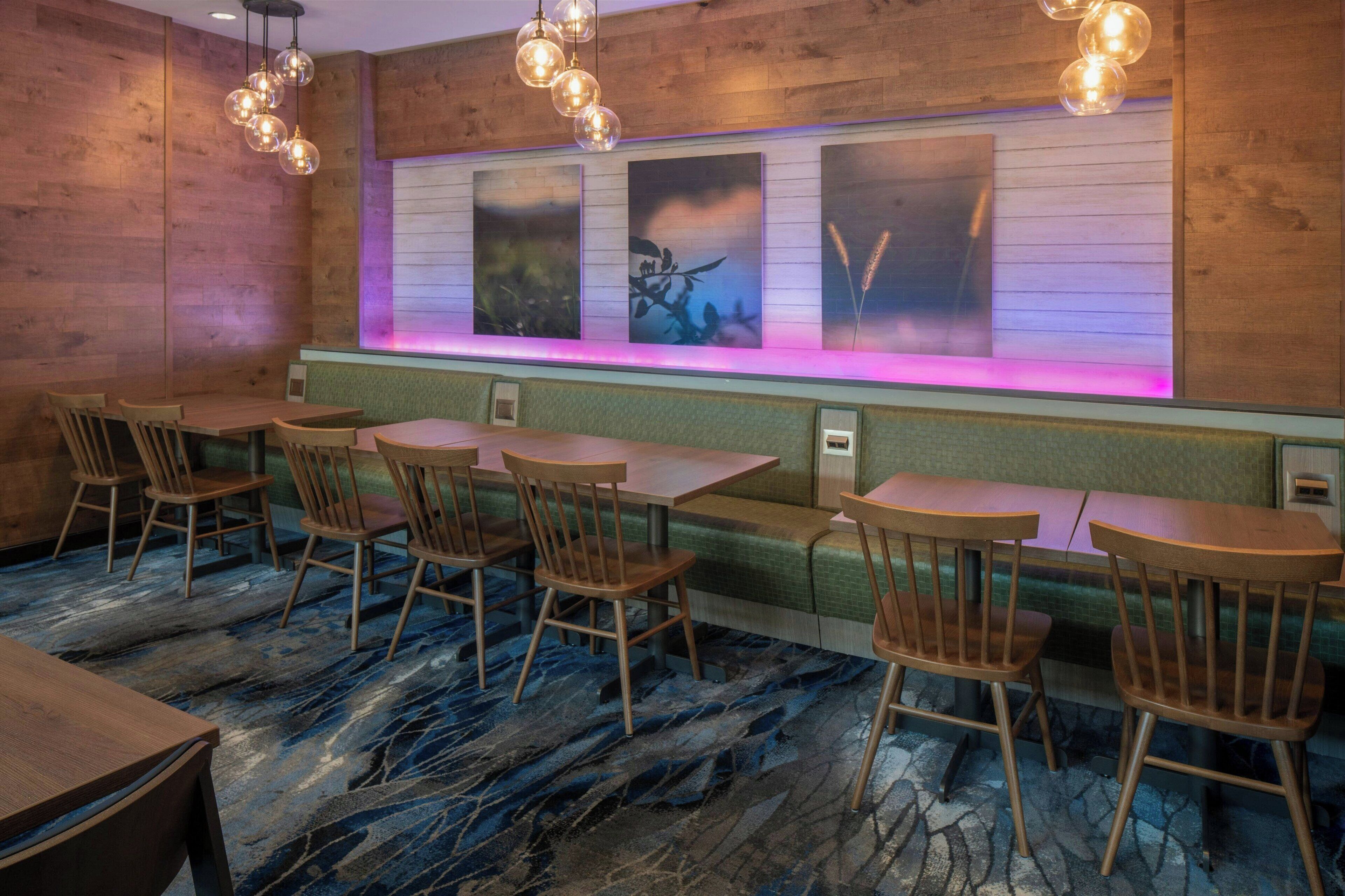Een restaurant met houten wanden, een lange toonbank met stoelen en een marmeren vloer.