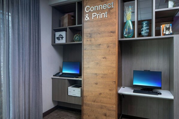 A workspace with two computers, a printer, and shelves with decorative items. - Fairfield Inn & Suites by Marriott Savannah Midtown (Savannah)