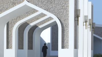 Una estructura arquitectónica moderna con arcos blancos y muros de piedra.